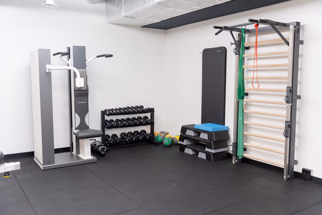 Sprossenwand, Hanteln und Kraftgerät im Trainingsbereich von FC Physio in Schwerte